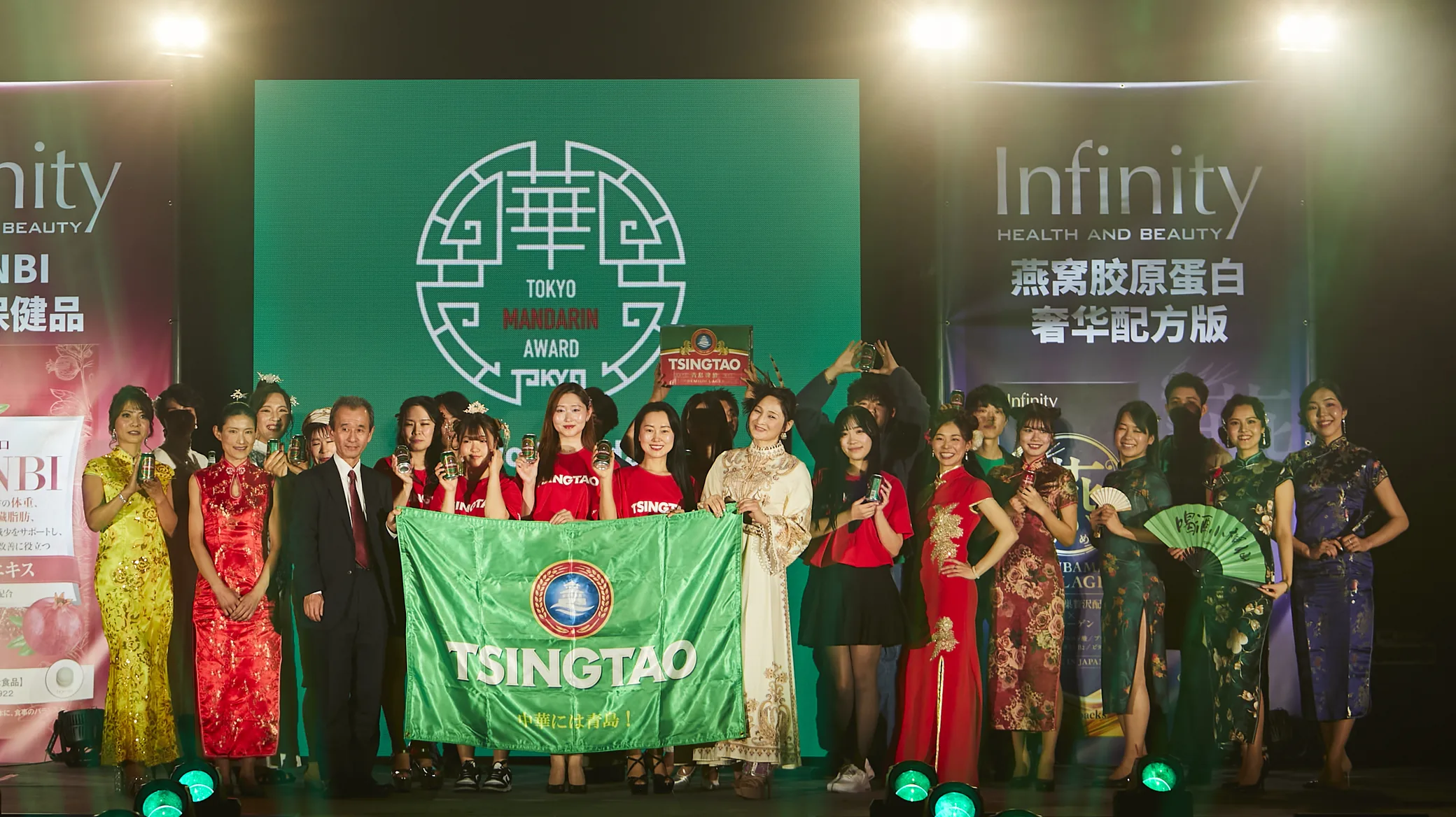 TSINGTAOフラッグを掲げる出演者の集合写真